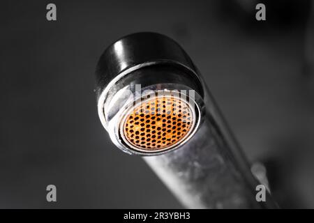 diffuseur d'aérateur dans le robinet en gros plan. Corrosion et dépôts de tartre de l'eau. Vieux robinet d'eau sale dans le lavabo sur un fond flou Banque D'Images