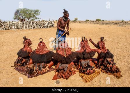 L'homme parle aux femmes de la tribu Himba dans le village Banque D'Images