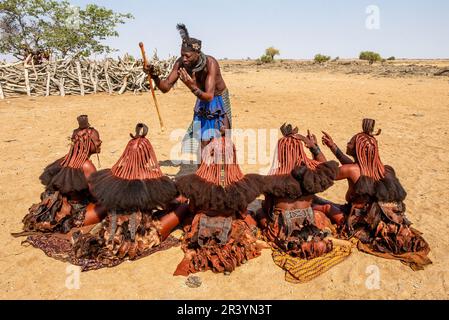 L'homme parle aux femmes de la tribu Himba dans le village Banque D'Images