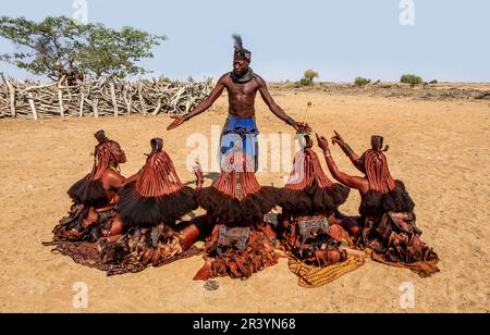 L'homme parle aux femmes de la tribu Himba dans le village Banque D'Images