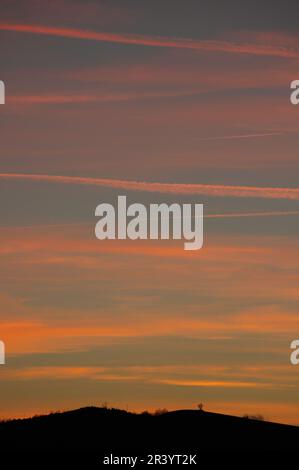 nuages et pistes d'avion au coucher du soleil Banque D'Images