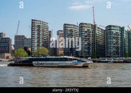 Londres, Royaume-Uni. 22nd mai 2023. Un Uber Boat passant des appartements sur la Tamise. De nombreux blocs d'appartements de luxe au bord de la rivière ont été construits le long de la Tamise à Vauxhall et Battersea, Londres. D'autres développements sont également en cours dans la région. Crédit : Maureen McLean/Alay Banque D'Images