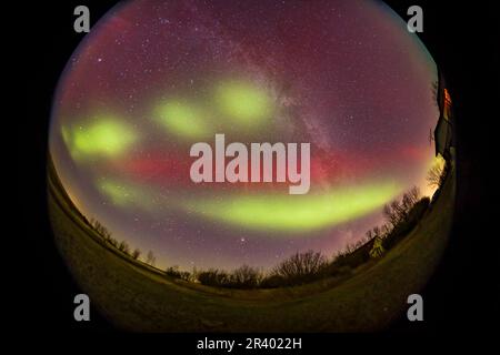 Une tempête aurorale de G2 regardant vers le sud à un arc rouge sombre avec des breloques vertes. Banque D'Images