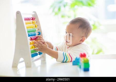 Bébé garçon jouant avec abacus en bois. Les enfants apprennent à compter. Adorables numéros d'apprentissage pour enfants asiatiques intelligents. Développement précoce et éducation. Banque D'Images