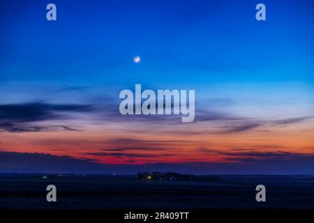 Le croissant de lune à cire vieux de deux jours avec Mercure à droite, Alberta, Canada. Banque D'Images