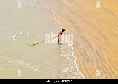 Les pêcheurs et les femmes travaillent pour attraper des crevettes dans la rivière le matin chaud et ensoleillé. Banque D'Images