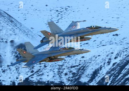 F/A-18C les avions de chasse Hornet de l'Armée de l'Air suisse volant au-dessus d'une neige couvraient Axalp, Suisse. Banque D'Images