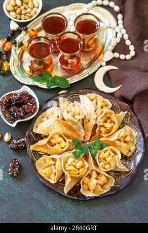 Cuisine arabe. Fête de Kareem de Ramadan. Menu du Ramadan, katayef à crêpes arabes (kataïev, qatayef) avec garniture aux pommes et cannelle Banque D'Images