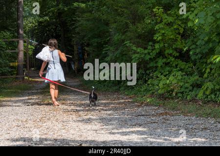 Un enfant abandonné sans-abri affamé cherche de la nourriture et un abri avec son petit chien Banque D'Images