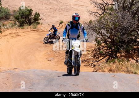 Moto hors route grimpant sur un dôme en grès de la piste fins & Things, près de Moab, Utah. Banque D'Images