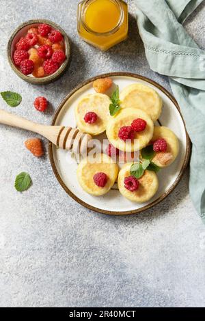 Crêpes maison au fromage cottage sans gluten (syrniki, beignets de caillé) avec baies sur fond de pierre. Crêpes à la ricotta, table de petit déjeuner le matin. V Banque D'Images