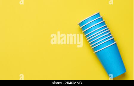 Gobelets en papier jetables sur fond jaune, vue du dessus Banque D'Images