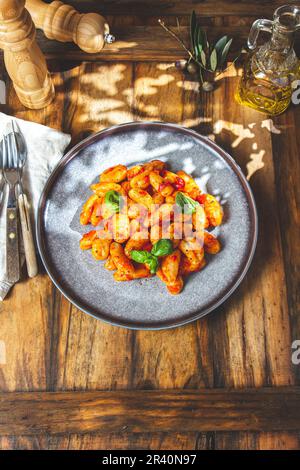 Gnocchi italien avec sauce tomate et basilic sur fond de bois Banque D'Images