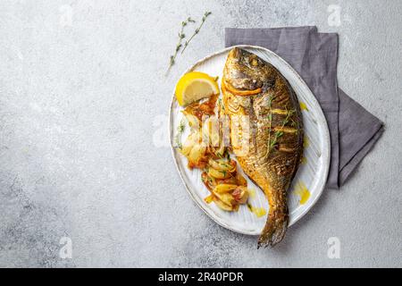 La dorade grillée ou dorada sur plaque gris. Fond gris Banque D'Images