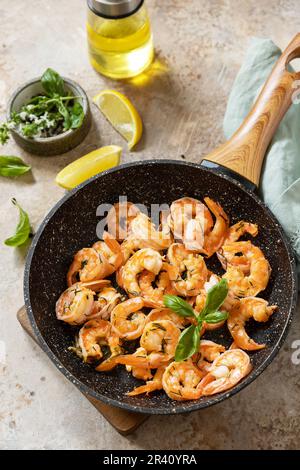 Crevettes épicées à l'ail crevettes bouillies et herbes, crevettes dans une poêle avec citron. Fruits de mer, coquillages. Banque D'Images