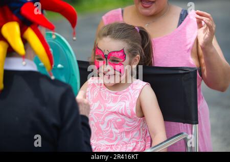 Rues ouvertes - Hyannis, Massachusetts, États-Unis. Une jeune fille examine sa peinture de visage dans un miroir. Banque D'Images