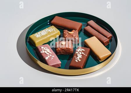 Ensemble de barres de desserts avec différents types de chocolat sur fond clair. Lumière dure, ombre profonde Banque D'Images