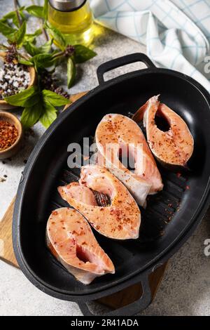 Morceaux de filet de saumon frais avec épices sur un gril. Fruits de mer, cuisine. Banque D'Images