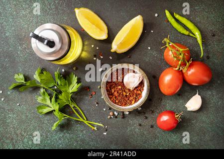 Alimentation saine alimentation végétarienne. Diverses herbes et épices pour cuisiner sur fond sombre. Vue de dessus. Banque D'Images