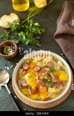 Soupe traditionnelle de chou de Zelnacka avec saucisses et légumes dans un bol sur une table en pierre. Cuisine tchèque. Banque D'Images