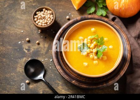 Soupe végétarienne à la crème de potiron et de pois chiches sur une table rustique en bois. Nourriture de confort, l'automne et l'hiver concept de nourriture lente saine. Co Banque D'Images