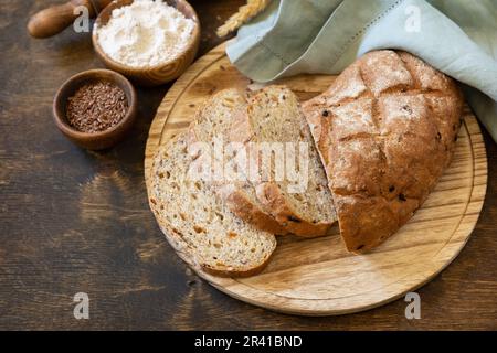 Cuisson maison. Pain de grains de blé entier, son de blé, graines, bio-ingrédients sur fond rustique de table, saine farce Banque D'Images