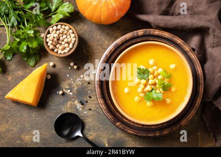 Soupe végétarienne à la crème de potiron et de pois chiches sur une table rustique en bois. Nourriture de confort, l'automne et l'hiver concept de nourriture lente saine. Vue de dessus. Banque D'Images