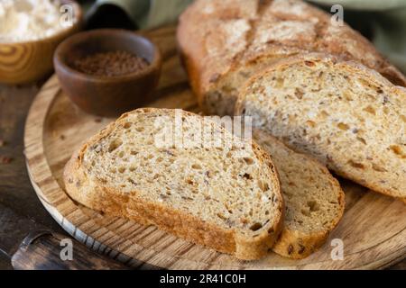 Pain de grains de blé entier, son de blé, graines, bio-ingrédients sur fond de table rustique, mode de vie sain. Banque D'Images