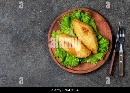 Plat traditionnel du Chili Pérou PAPA RELLENA purée de pommes de terre farcies de viande sur plaque de bois Banque D'Images