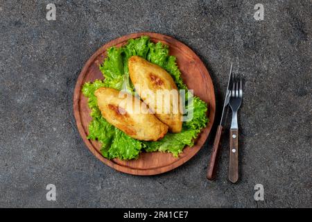 Plat traditionnel du Chili Pérou PAPA RELLENA purée de pommes de terre farcies de viande sur plaque de bois Banque D'Images
