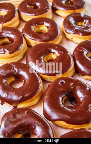 Beignets de levure à demi-vitrage avec glaçage au chocolat sur fond blanc Banque D'Images