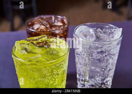 Trois boissons gazeuses Coca-Cola ou Pepsi sodas brunes, vert lime, sodas pétillantes Banque D'Images