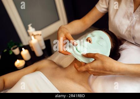 Esthéticienne appliquant le masque d'alginate sur le visage de la femme avec une peau douce et lisse Banque D'Images