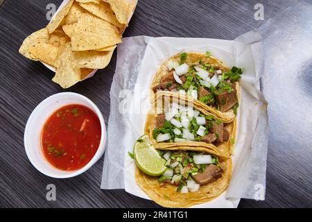 Repas 3 tortilla au maïs lengua vache langue de boeuf rue tacos mexicain avec chips salsa rouge Banque D'Images