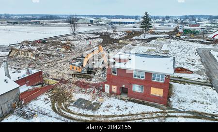 Une antenne de traces de pneus dans la neige sur un chantier de construction impliquant la destruction d'un ancien bâtiment Banque D'Images