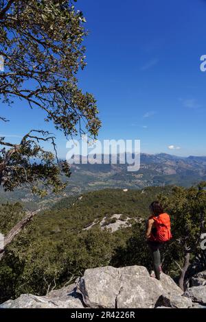 Femme avec sac à dos bénéficiant de la vue sur les montagnes tramuntana et l'ermitage de Maristela, son Ferra, Esporles, Iles Baléares, Espagne. Banque D'Images