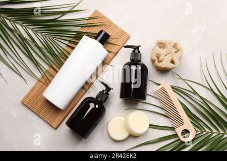 Composition de la couche plate avec barres de shampooing solides et bouteilles de produit cosmétique sur table gris clair Banque D'Images