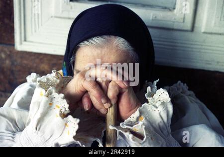 Comté de Maramures, Roumanie, 2000. Femme âgée portant des vêtements traditionnels. Femme dans une posture méditante/triste/priante. Banque D'Images