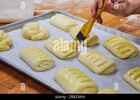 Beurre brossé sur des pâtisseries crues non cuites de dinde et de croissants Banque D'Images