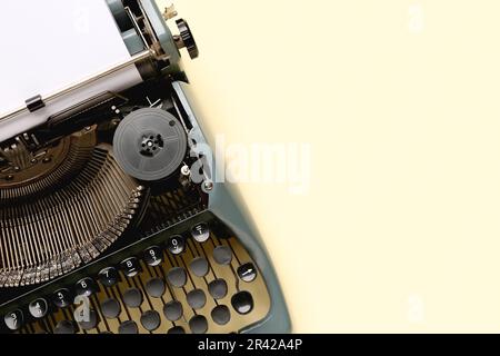Machine à écrire vintage avec feuille de papier vierge sur fond jaune Banque D'Images