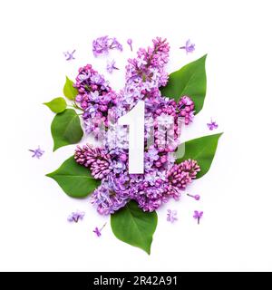 Papier numéro un sur fond de fleurs lilas. Création minimale mise en page avec éléments naturels pour votre conception Banque D'Images