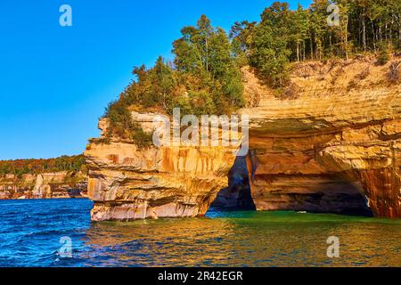 Arcade en pierre dans les rochers illustrés falaises avec le lac supérieur et forêt verte sur pierre Banque D'Images