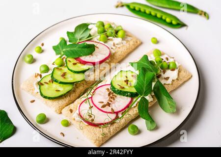 Des sandwiches sains avec du fromage doux et des légumes crus sur du pain croustillant Banque D'Images