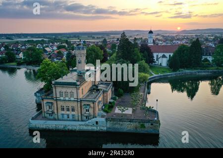 Langenargen, Allemagne. 26th mai 2023. Le soleil se lève derrière le château de Montfort, sur le lac de Constance. En arrière-plan, vous pouvez voir l'église paroissiale de Saint-Martin. (Vue aérienne avec drone) Credit: Felix Kästle/dpa/Alay Live News Banque D'Images