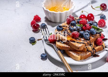 Petit déjeuner d'été avec pain grillé. Cuit avec des toasts aux baies (bleuets, fraises) et au miel, dessert sucré traditionnel du matin avec frais Banque D'Images