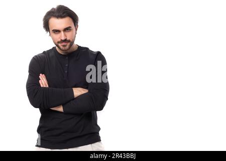 jeune homme macho européen brutal barbu avec perçage d'oreilles et cheveux noirs sur fond blanc isolé avec espace de copie Banque D'Images