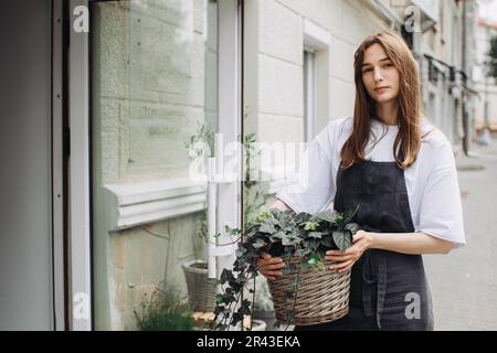 Fleuriste fille avec ivy près d'un fleuriste. Banque D'Images