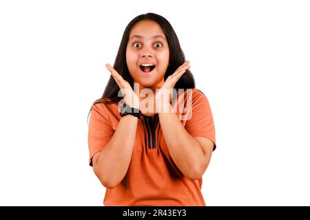 Image d'une jeune femme indienne excitée se tenant isolée sur fond blanc avec Copy Space. Regarder dans l'appareil photo. Banque D'Images