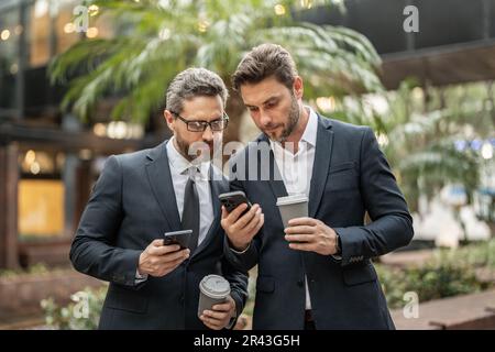 collègues professionnels avec rapports de stock par téléphone en combinaison. photo de collègues Banque D'Images