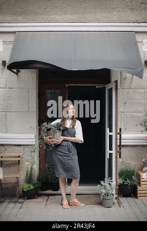 Fleuriste fille avec ivy près d'un fleuriste. Banque D'Images